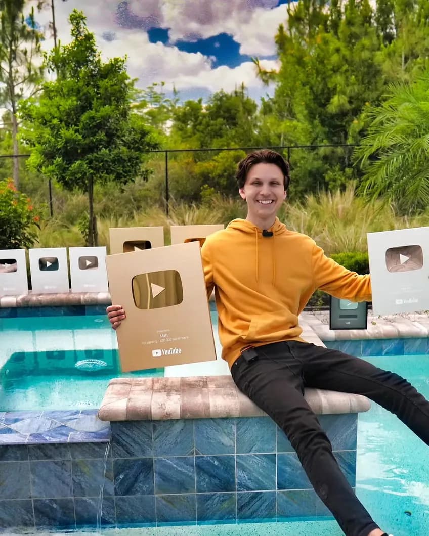 Matt Par smiling with his YouTube play button awards